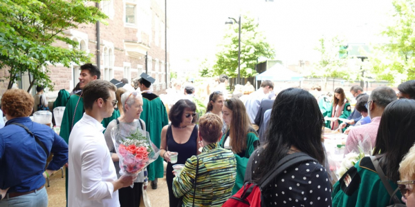 students and faculty mingle in the courtyard outside Seigle Hall